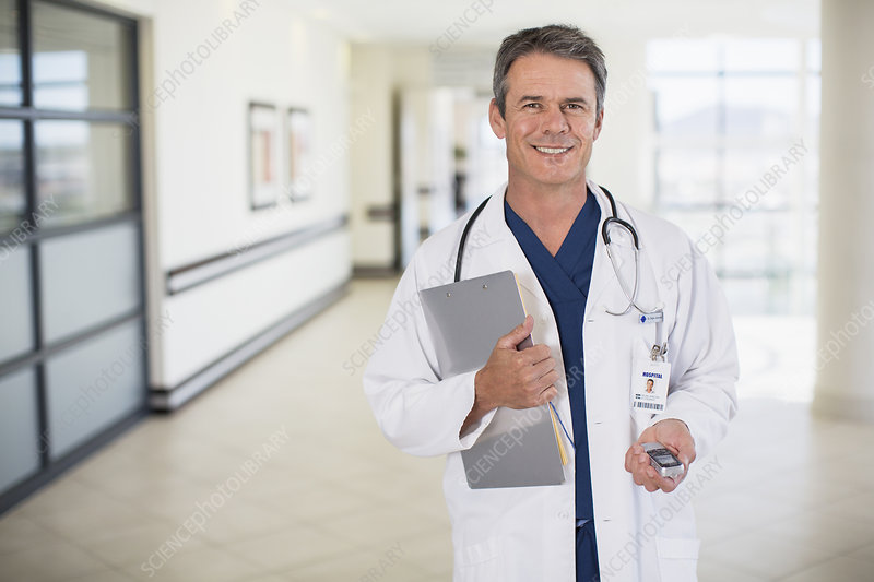 Portrait of smiling doctor in hospital corridor.